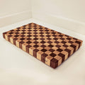 Wooden cutting board with checkered pattern on a white surface