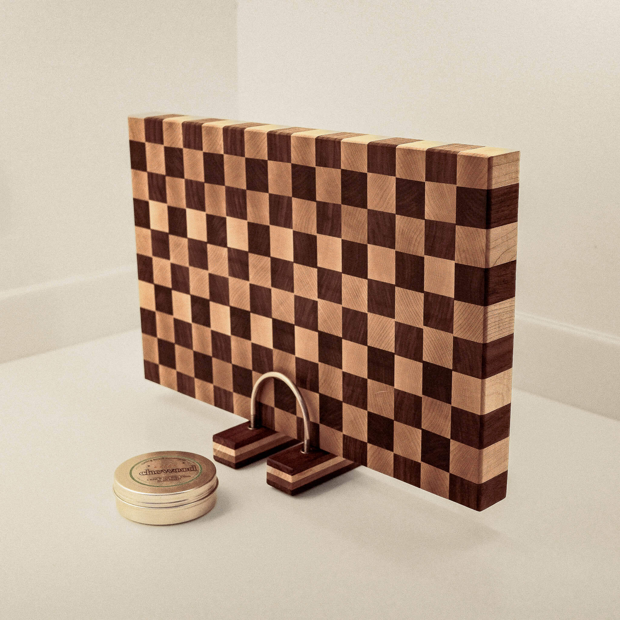 Wooden checkered cutting board with two wooden stands on a light background